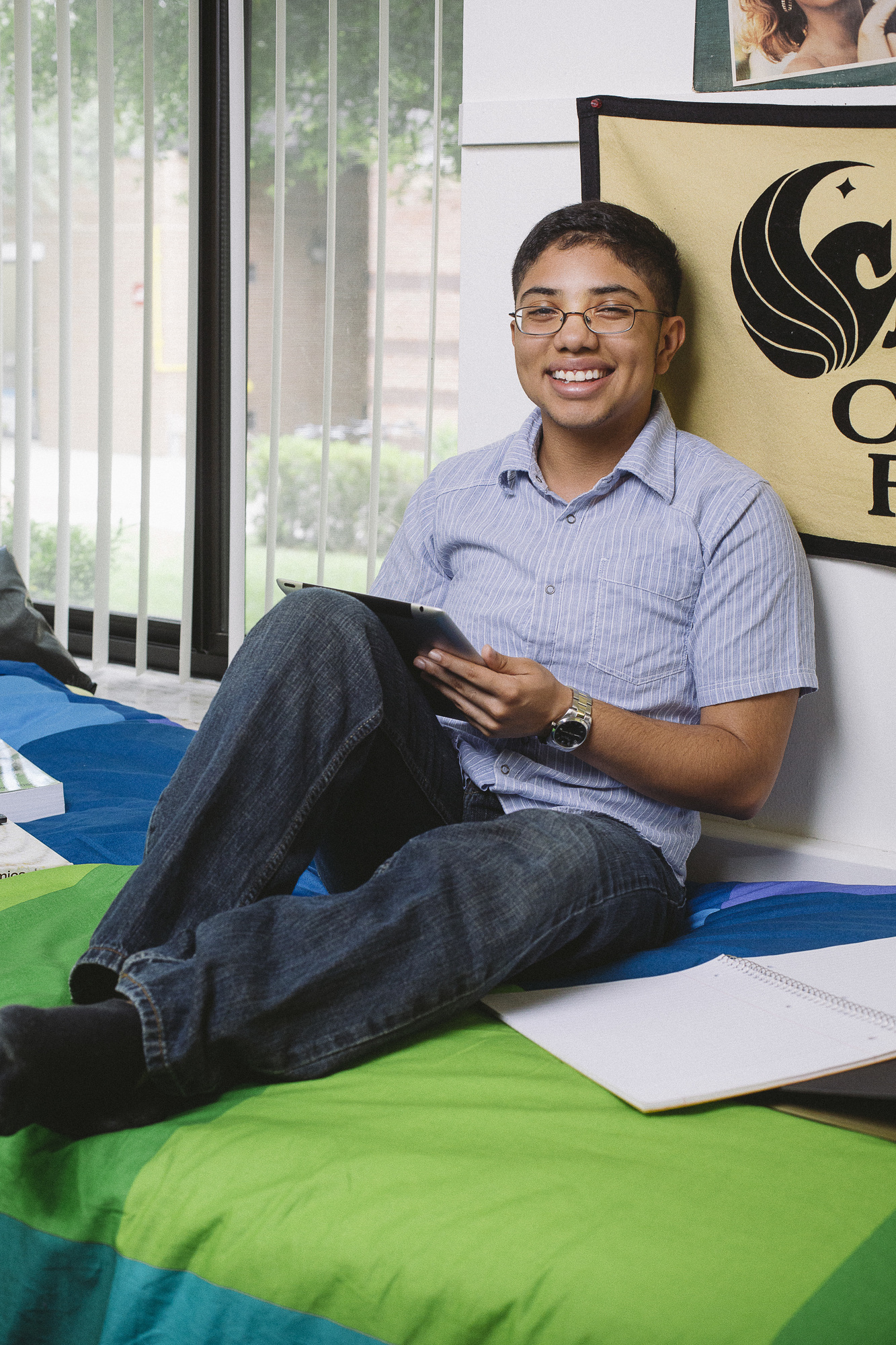 student sitting on dorm room bed