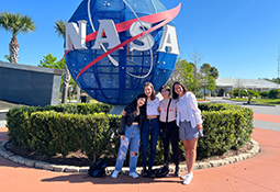 Students in front of NASA logo at Kennedy Space Center
