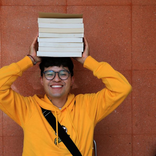 UAM Student Holding Books on his head