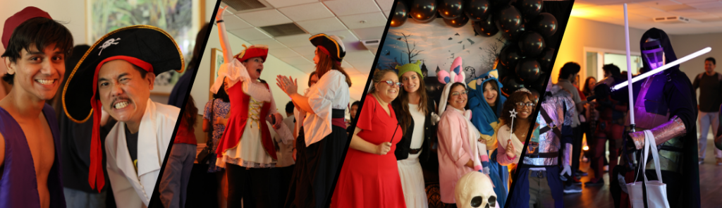 Participants dressed in various costumes, including pirate outfits and colorful character attire. Decorations include black balloons and a backdrop with a Halloween theme featuring bats and a moon. A person holds a glowing lightsaber prop in a dimly lit room.